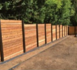 Tall horizontal slat fence along a yard border