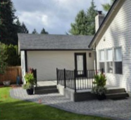 Paver patio with raised porch and black railings